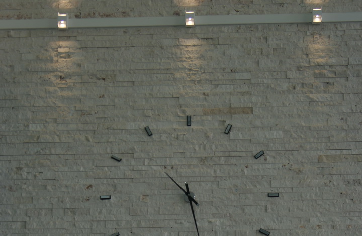 ساعت بر روی دیواره سنگ قیچی با نورپردازی