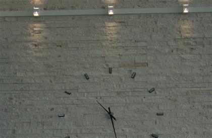 ساعت بر روی دیواره سنگ قیچی با نورپردازی