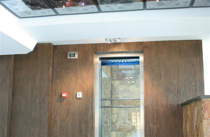 آسانسور پانوراما با سقف شیشه ای و دیواره چوبی